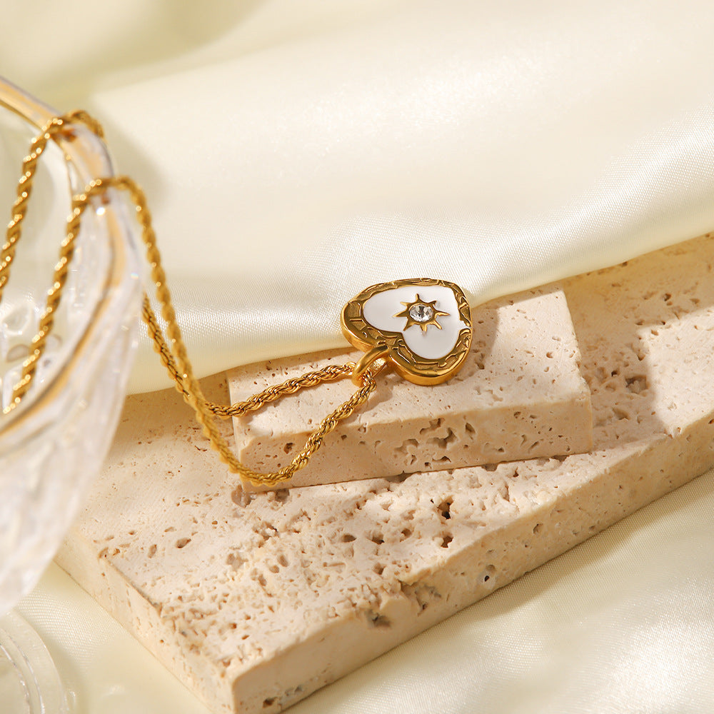 Alžběta – Zlatý náhrdelník s malými symbolickými přívěsky.