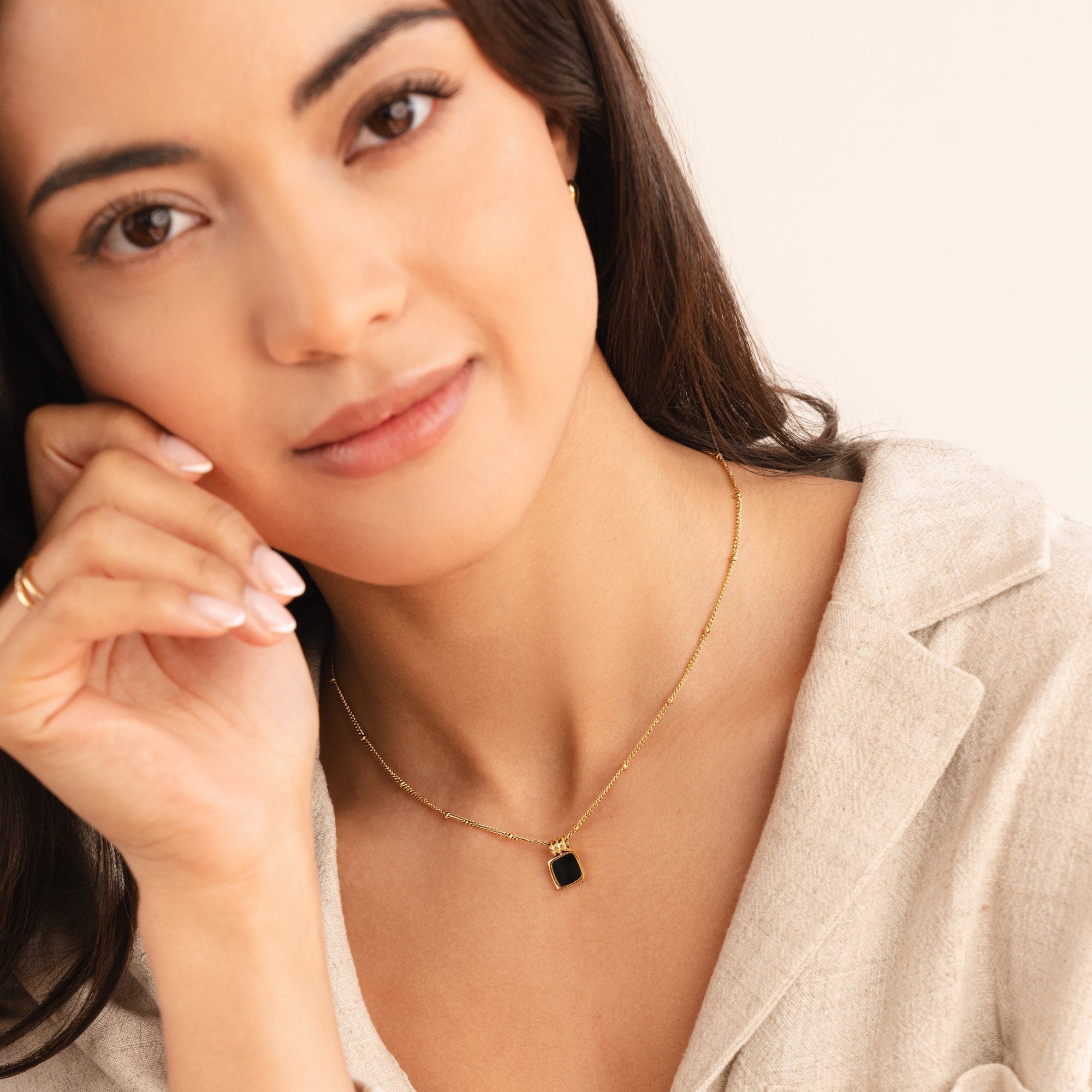 Selina - Collana in oro con pietra scura.