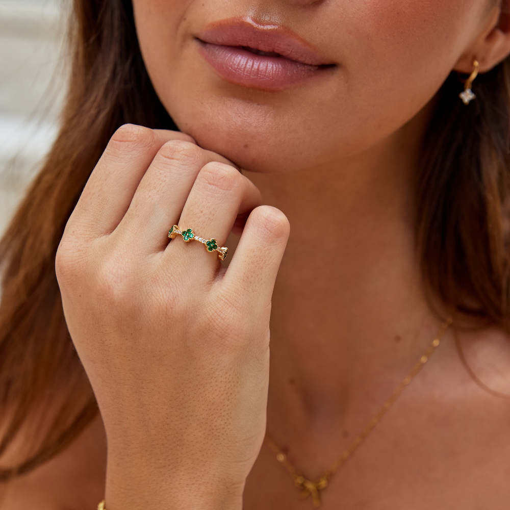 Annika – Anello placcato oro con dettagli floreali e un elemento in smeraldo.